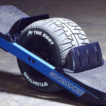 Image illustrates the goat tire for onewheel, sold exclusively from Flight Fins, with the paint pen in white applied to the lettering circling the tire that is set in a onewheel skateboard in front of a dark grey background.